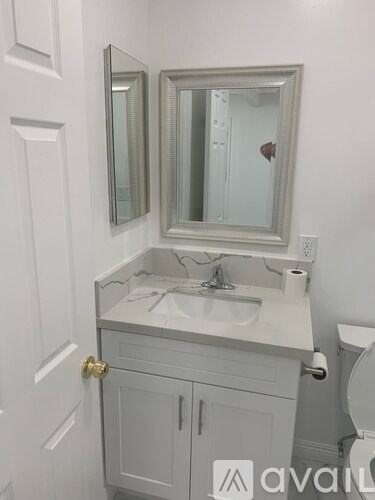 A bathroom with a sink, mirror, and toilet.