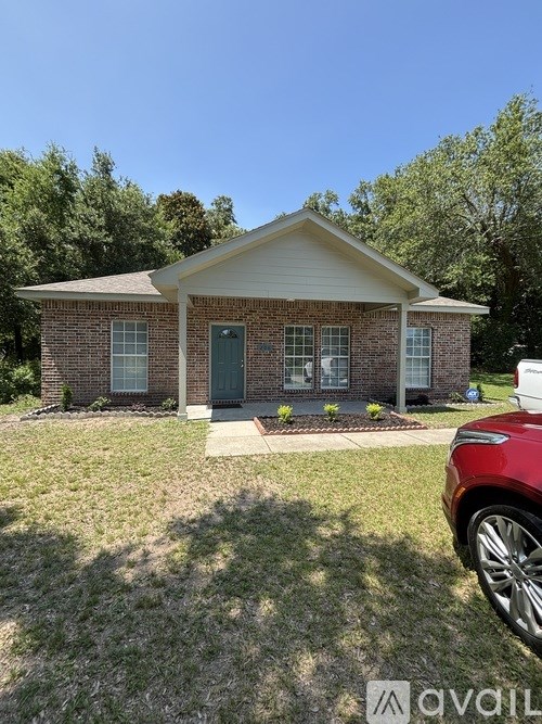 A small house with a red car parked in front.