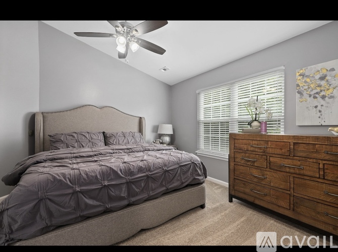 A bedroom with a large bed and a dresser.