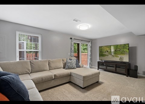 A living room with a beige sofa and a flat screen TV.
