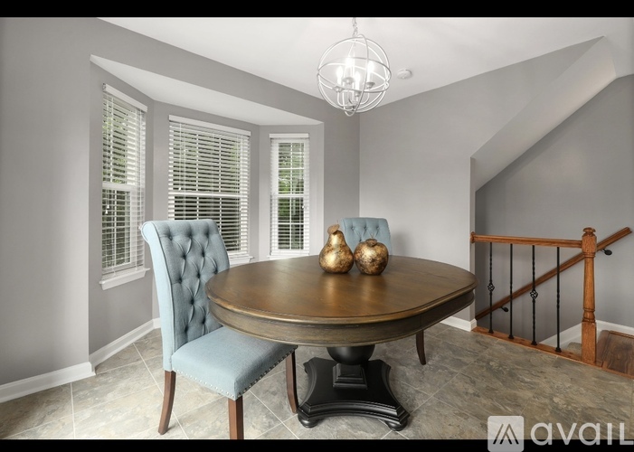 A dining room with a round table and a blue chair.