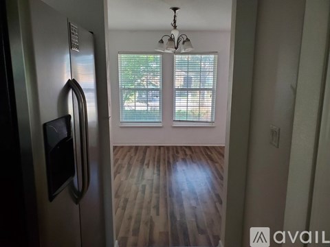 A kitchen with a stainless steel refrigerator and a chandelier.
