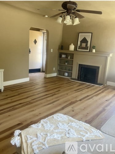 A living room with a fireplace and a rug on the floor.