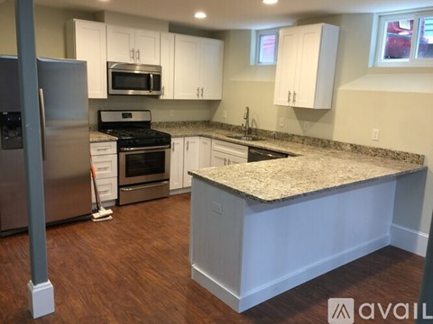 A kitchen with a granite countertop and white cabinets.