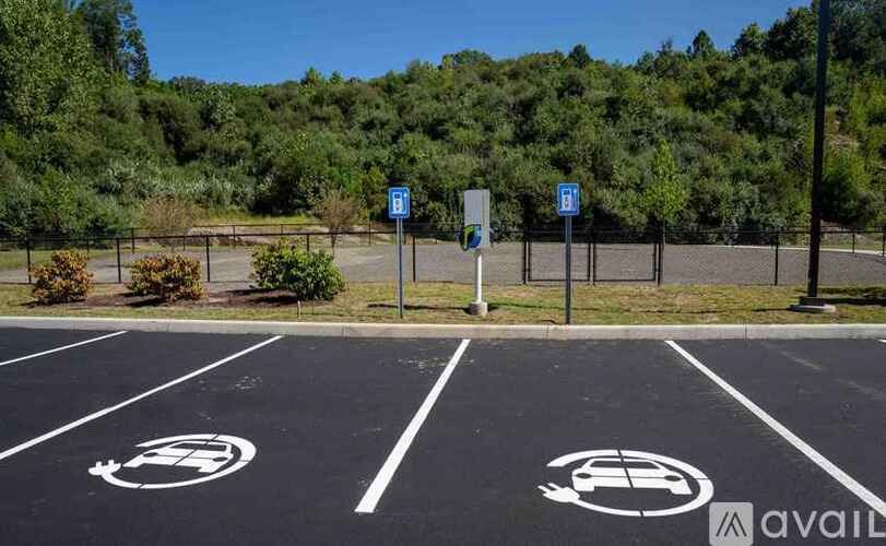 A parking lot with a sign that says "available" and a symbol of a car with a plug.