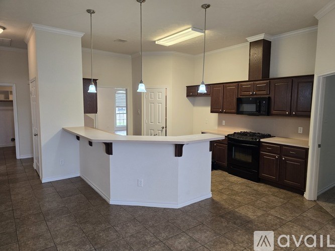 A kitchen with a white island and brown cabinets.