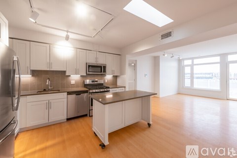 A kitchen with white cabinets and a wooden island.