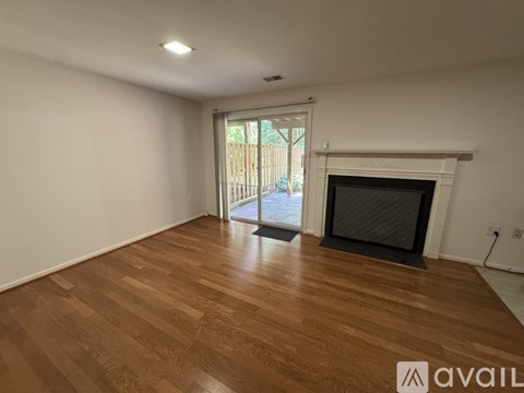 A room with a fireplace and wooden flooring.