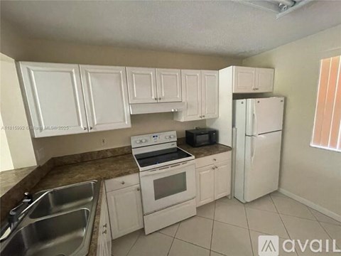 A kitchen with white cabinets and appliances.