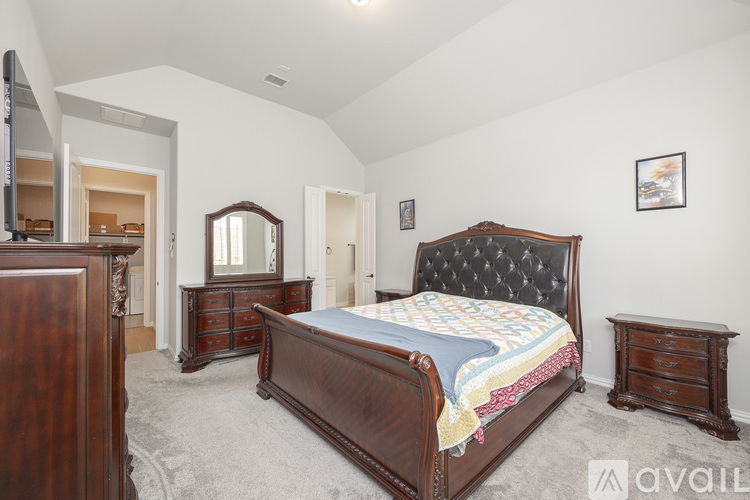 A bedroom with a large bed, a dresser, and a mirror.
