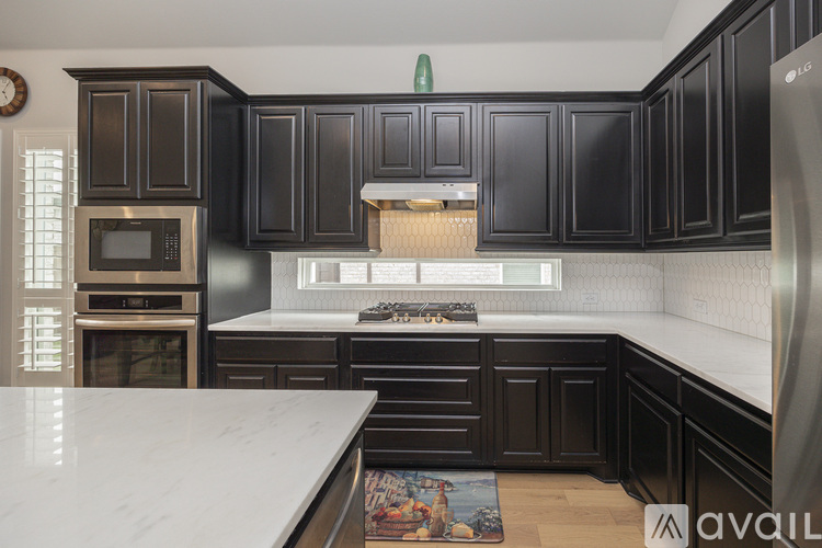 A kitchen with black cabinets and a white countertop.