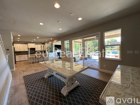 A spacious living room with a glass table and a checkered floor.