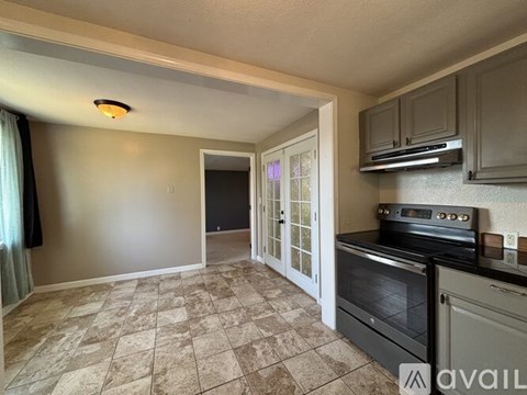 A kitchen with a tile floor and a stove top oven.