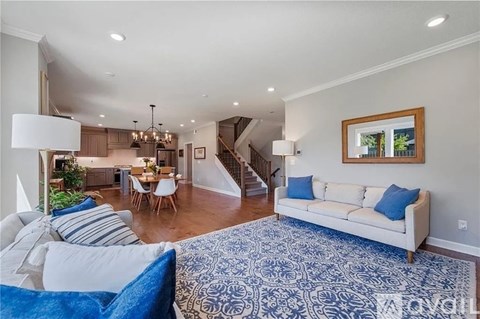 A living room with a white couch and a blue patterned rug.