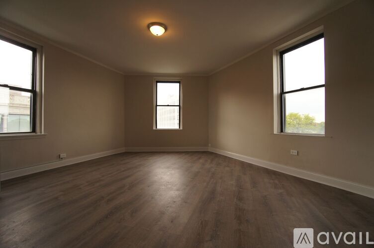 A room with wooden floors and two windows.