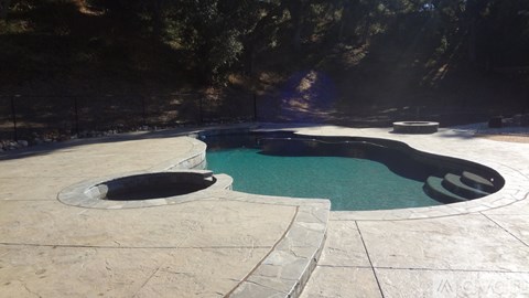 A round pool with a black circular object in the middle.