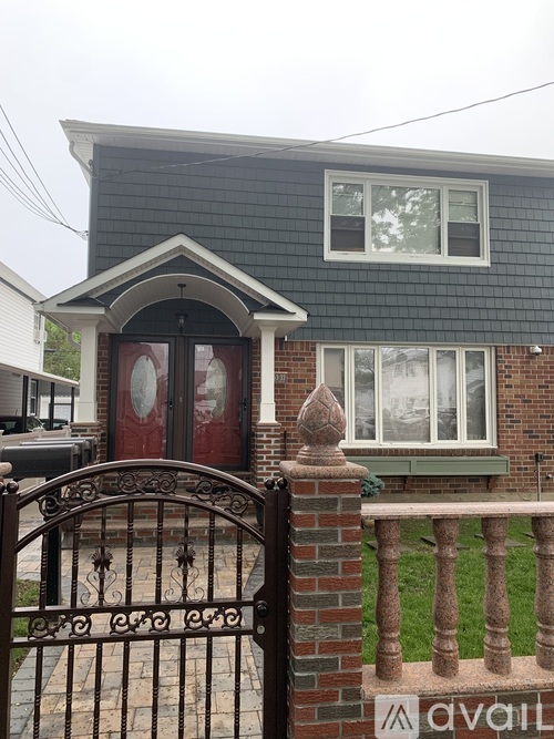 A house with a red door and a black gate.