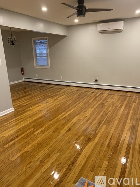 A room with wooden flooring and a ceiling fan.