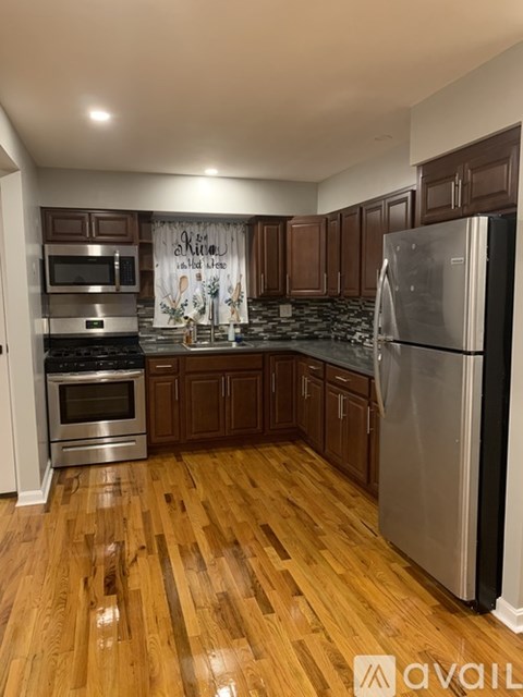 A kitchen with wooden floors and stainless steel appliances.