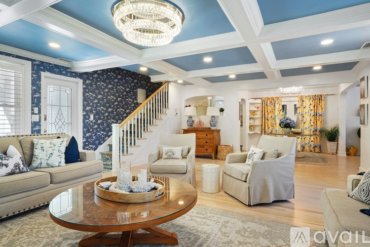 A living room with a blue ceiling and a wooden coffee table.