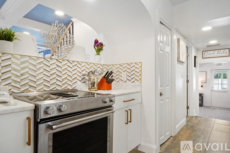 A kitchen with a stove top oven and a white tile backsplash.