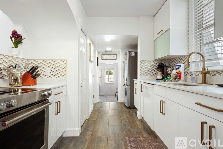 A kitchen with white cabinets and a black stove top oven.