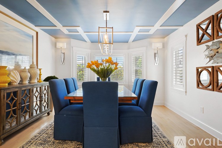 A dining room with a wooden table and blue chairs.