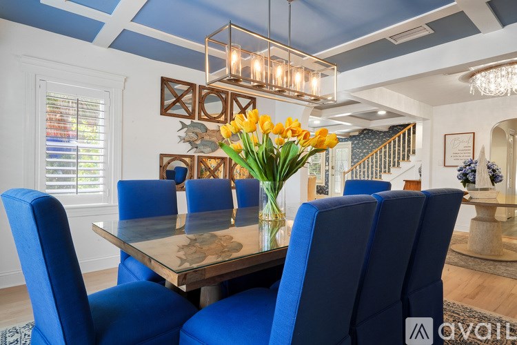 A dining room with a table and blue chairs.