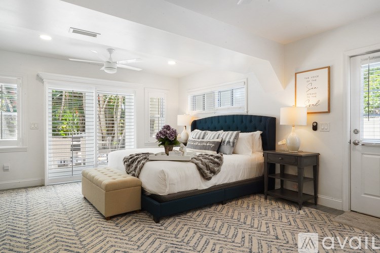 A bedroom with a large bed and a ceiling fan.