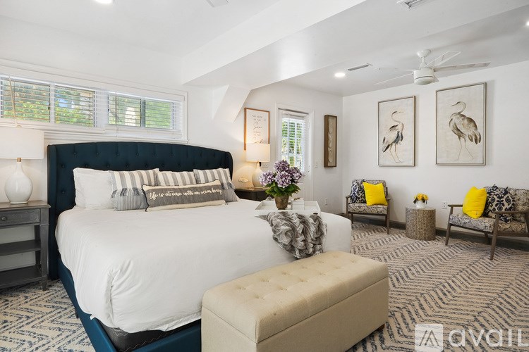 A bedroom with a large bed and a bench.