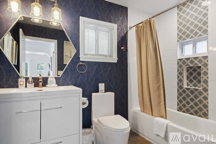 A bathroom with a toilet, sink, and shower.