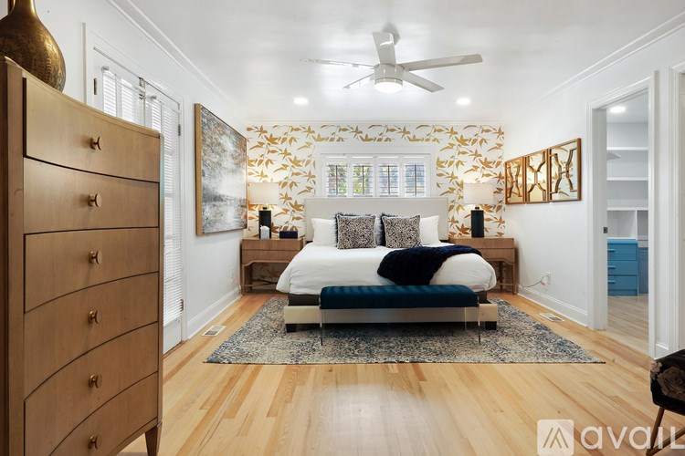 A bedroom with a bed, a dresser, and a ceiling fan.