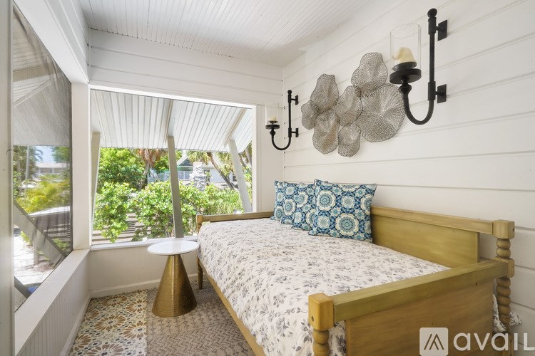 A bedroom with a bed, a table, and a chandelier.
