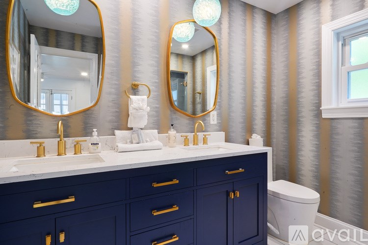 A bathroom with two sinks and gold fixtures.