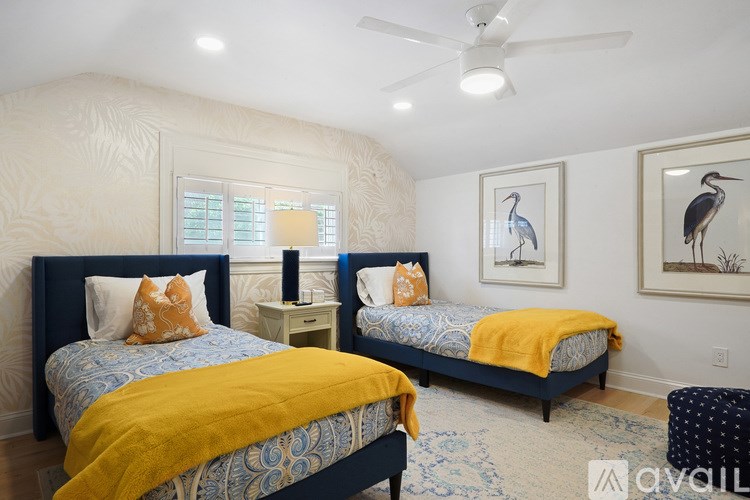 A bedroom with two beds and a ceiling fan.