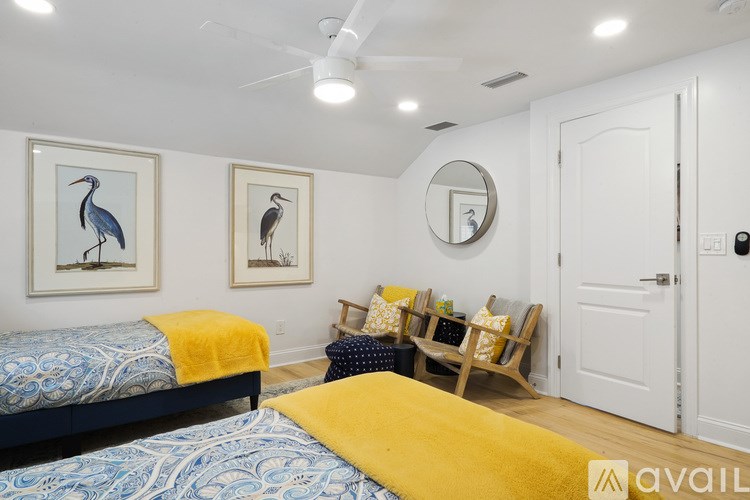 A bedroom with two beds and a ceiling fan.