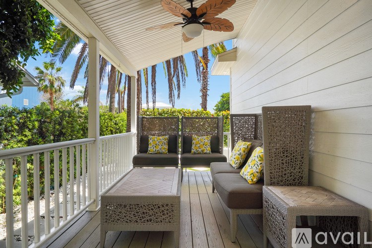 A wooden porch with a bench and pillows.