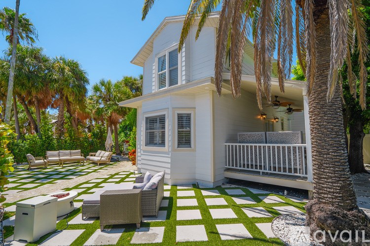 A white house with a balcony and a green and white checkered floor.