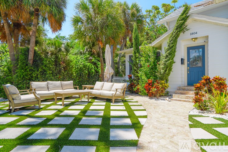 A white house with a blue door and a garden in front.