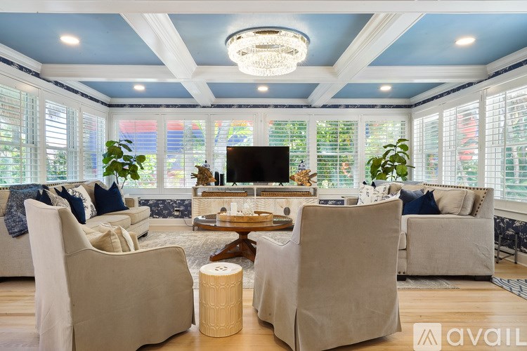 A living room with a television, two chairs, and a coffee table.