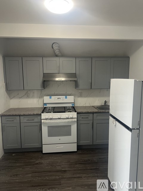 A kitchen with a white stove and a white refrigerator.