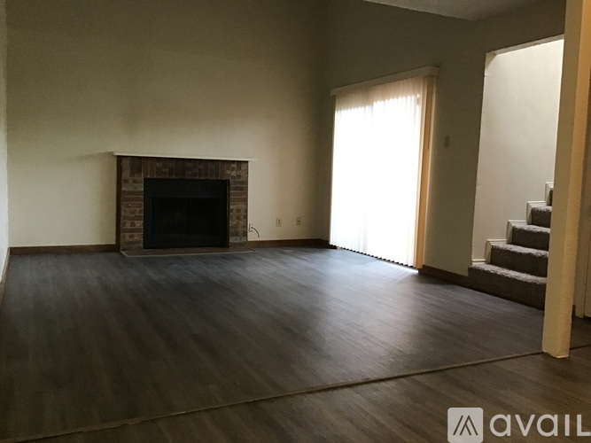 A living room with a fireplace and a staircase.