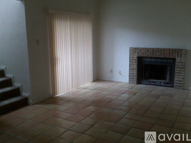 A room with a fireplace and tiled floor.