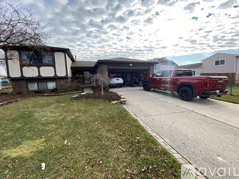 A red truck is parked in a driveway.