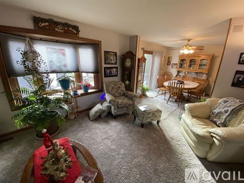A living room with a couch, chair, and a table with a Christmas tree on it.