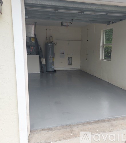 A garage with a white floor and a window on the right side.