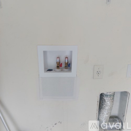 A white wall with a shelf and a vent.