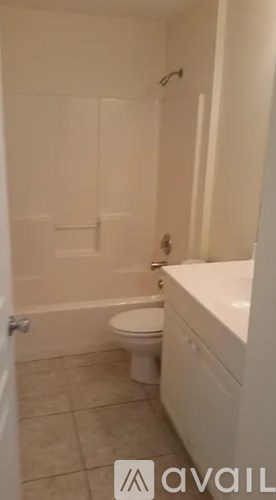 A white bathroom with a toilet, sink and bathtub.
