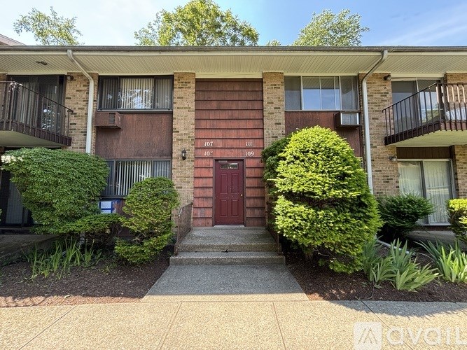 A red door is the entrance to apartment 107.