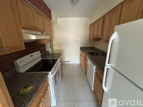 A kitchen with wooden cabinets and a white fridge.